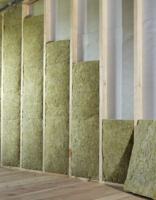 Wooden frame for future walls insulated with rock wool and fiberglass insulation staff for cold barrier. Comfortable warm home, economy, construction and renovation concept.